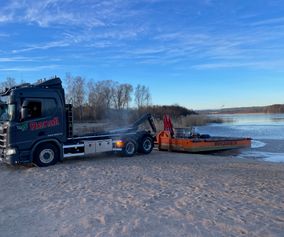 Barge being launched on a beach.